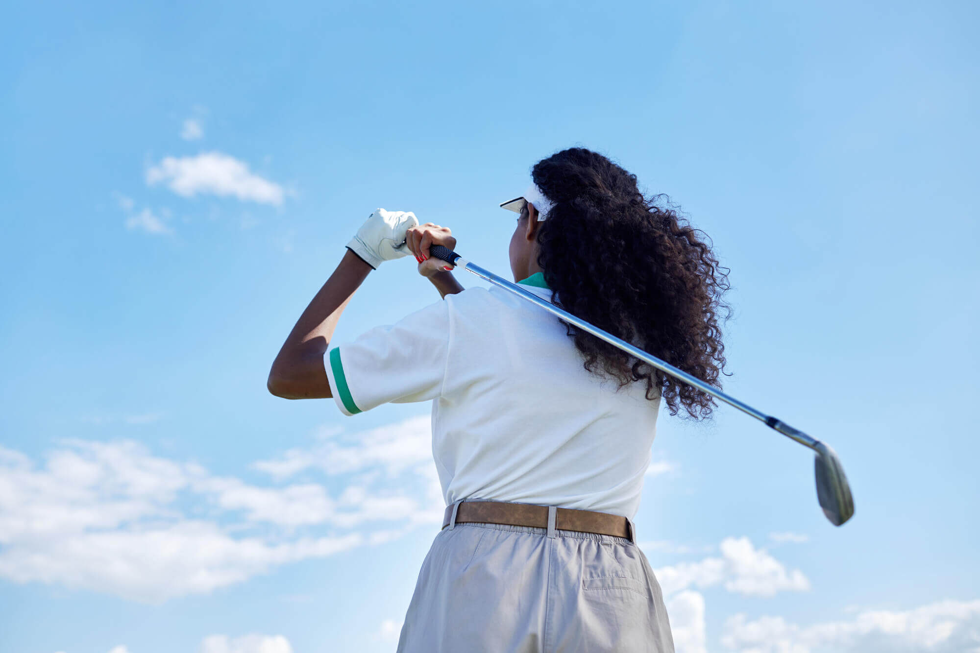 back-view-of-black-young-woman-playing-golf-agains-2023-11-27-05-28-11-utc.jpg