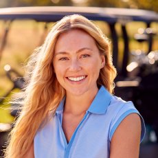 portrait-of-smiling-woman-golfer-standing-by-buggy-2023-11-27-04-50-39-utc.jpg